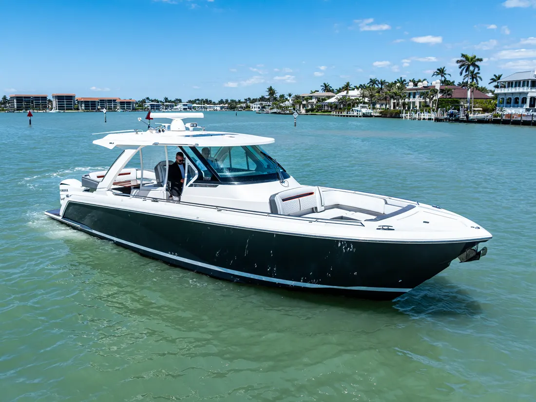 Tiara 38 LS cruising past Naples waterfront homes